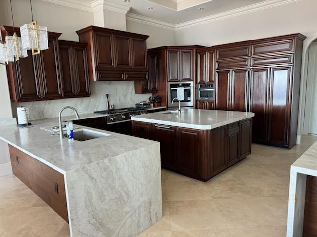 A modern kitchen with dark wood cabinets, white stone countertops, a large center island, and neutral tile flooring.