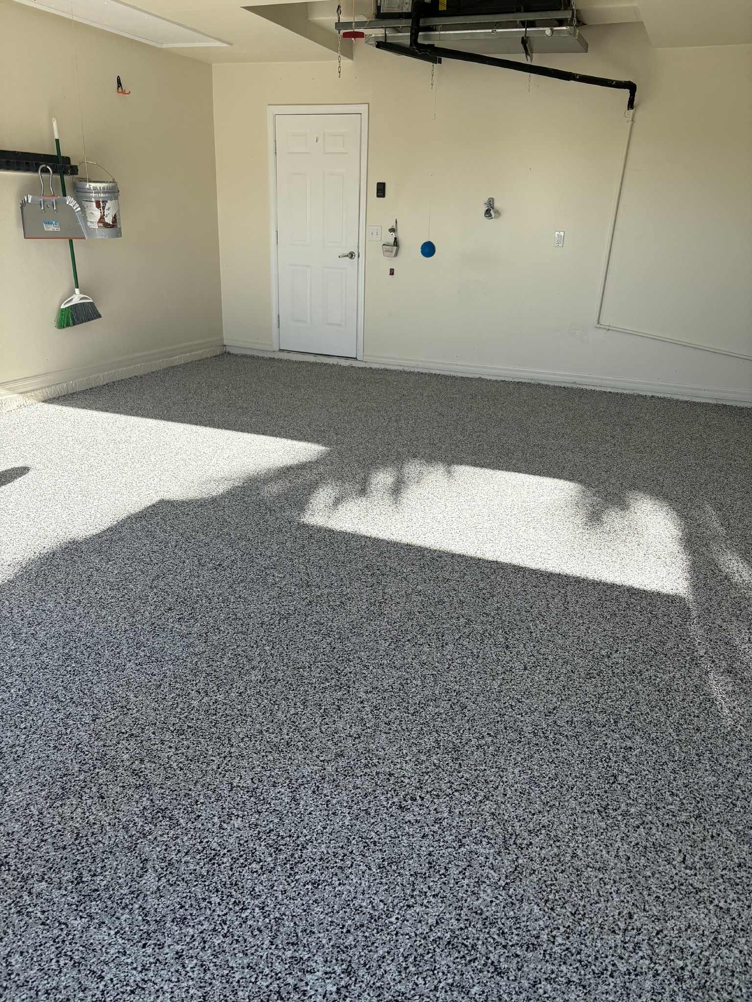 Person wearing pink gloves scrubbing white bathroom tiles with a green and white brush.