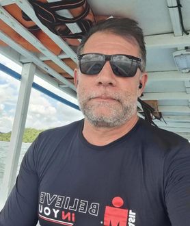 Um homem usando óculos escuros e uma camisa que diz alegria