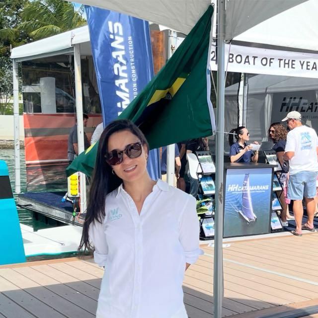 Uma mulher está em frente a uma placa que diz barco do ano