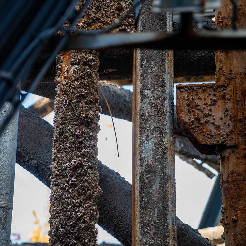 A close up of a rusty metal structure with pipes and wires