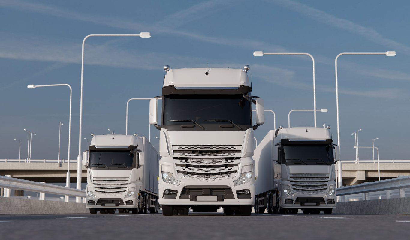 Three white semi trucks are driving down a highway.