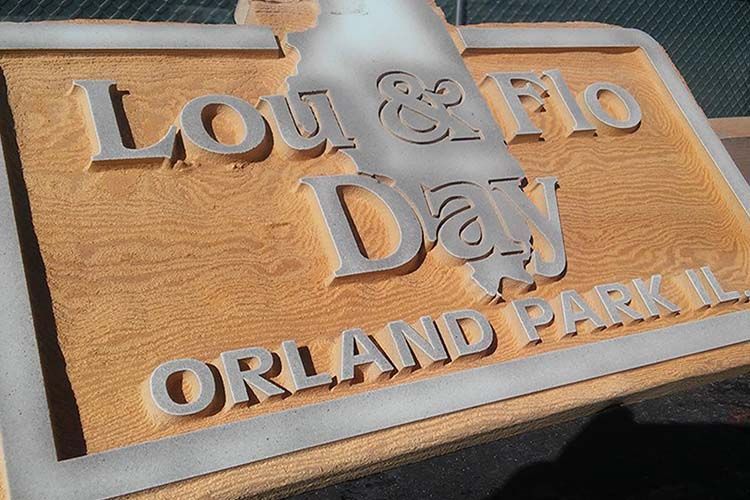 A wooden sign that says lou & flo orland park ii