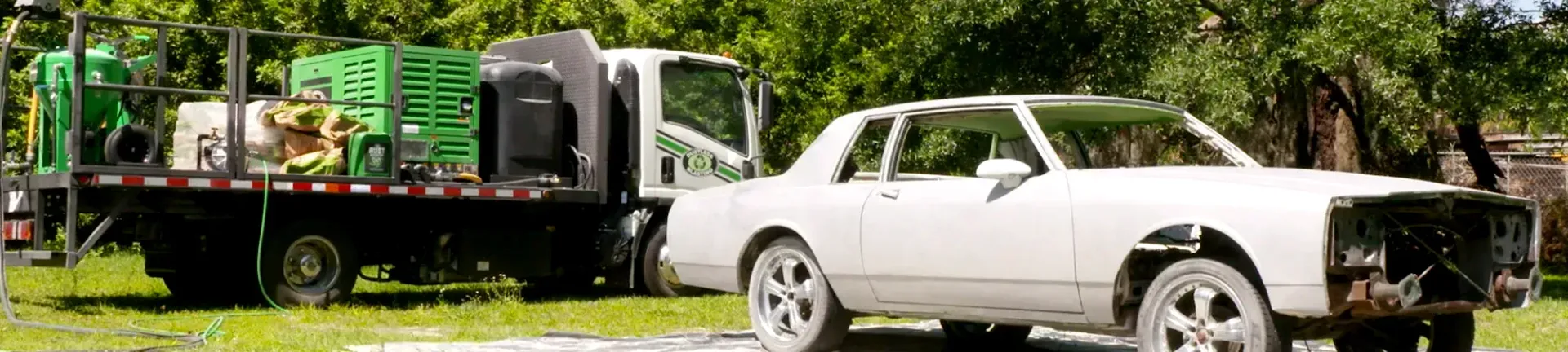A white car is parked next to a tow truck.ontact Lyons!
