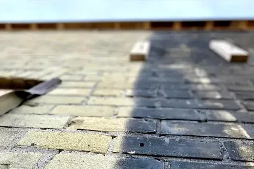 A close up of a brick walkway being painted.