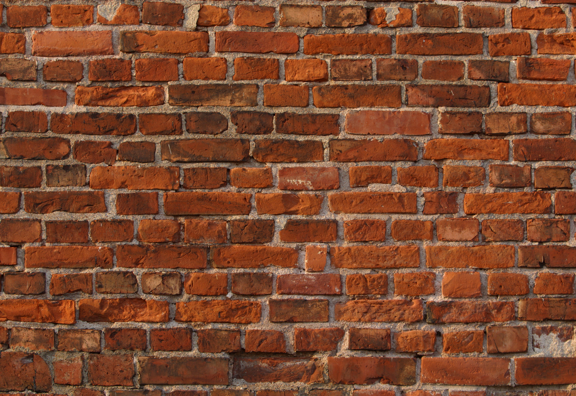 A close up of an old red brick wall