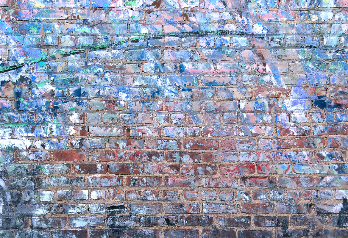 A close up of a brick wall with graffiti on it.