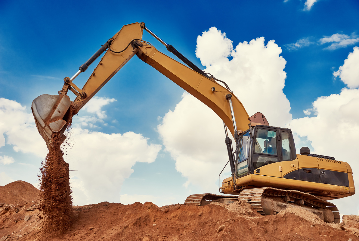 A yellow excavator is digging a hole in the dirt.