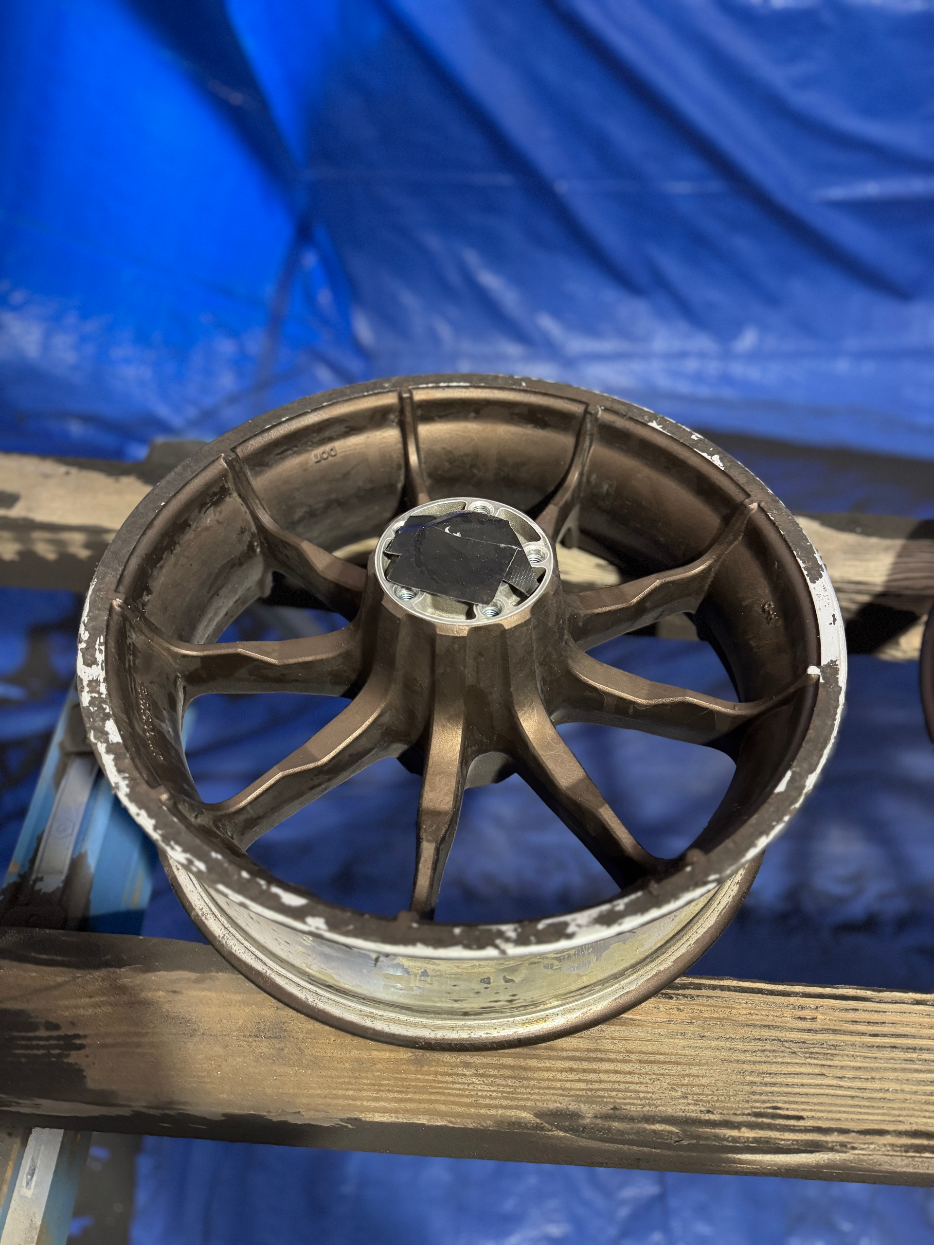 A wheel is sitting on top of a wooden plank.