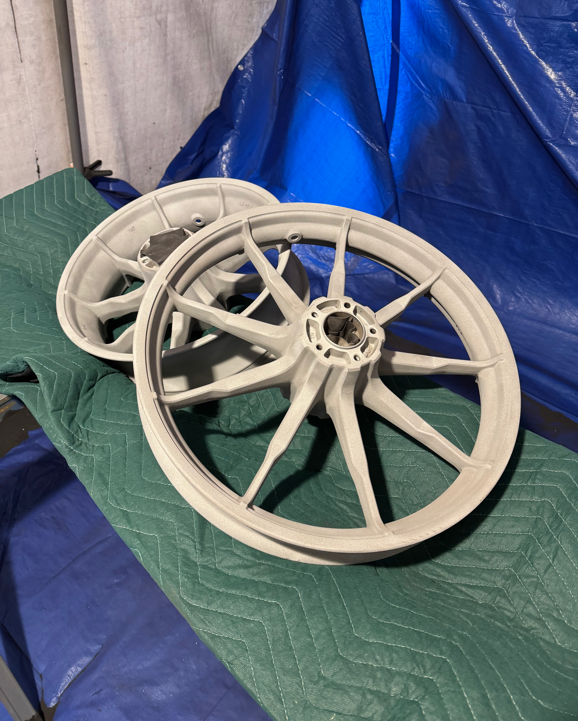 A pair of wheels are sitting on top of a green tarp.