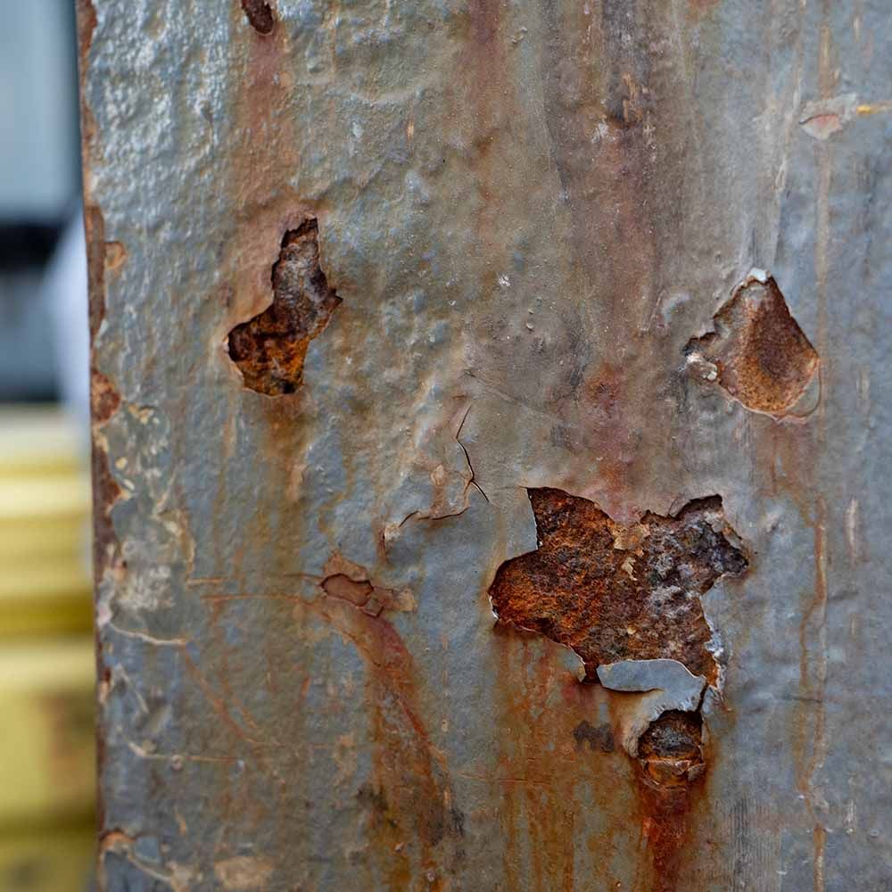 A close up of a piece of rusty metal with holes in it.