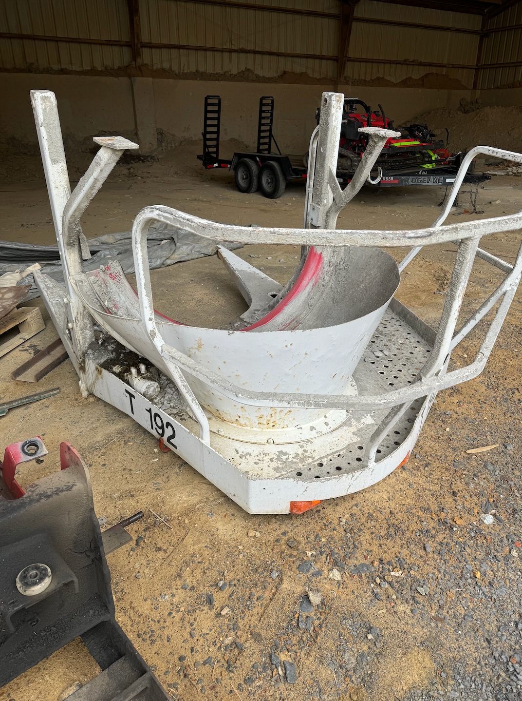 A piece of metal is sitting on top of a wooden table in a warehouse.