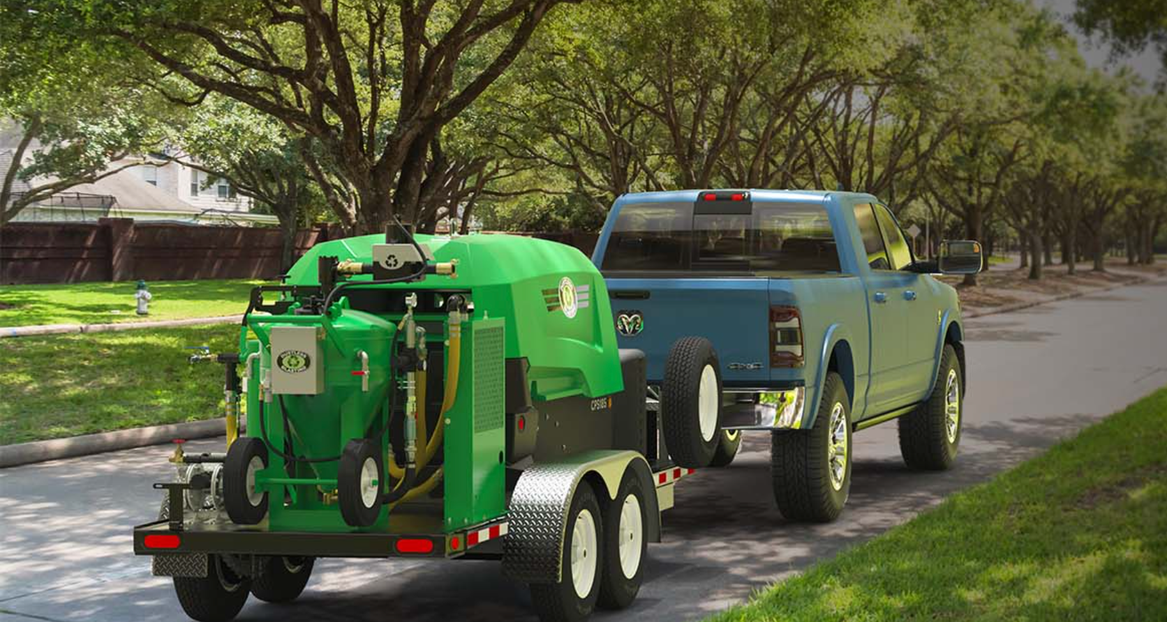 A blue truck is pulling a green trailer with a machine on it.