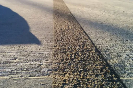 A shadow of a person is cast on a concrete surface