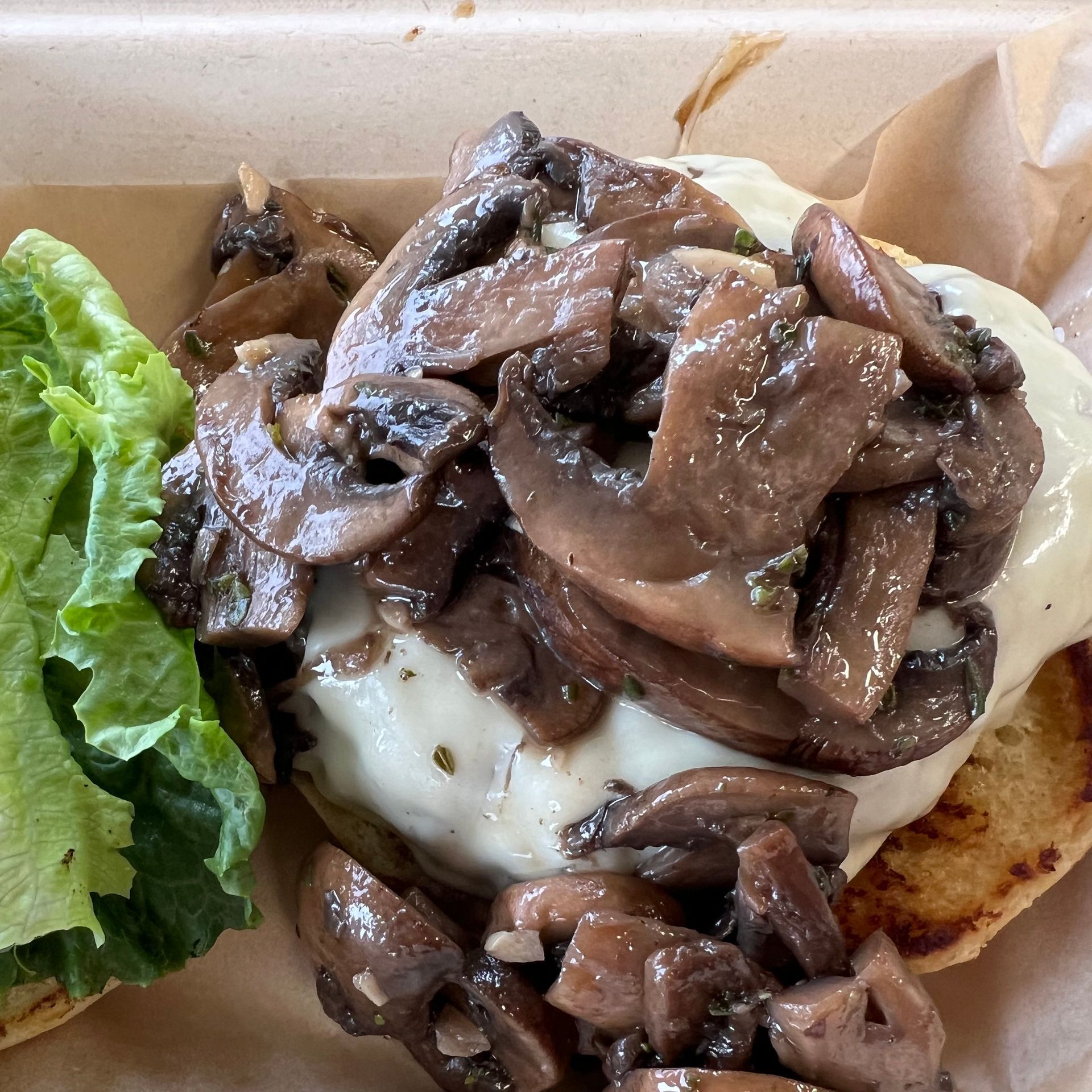 A hamburger with mushrooms and cheese on a bun