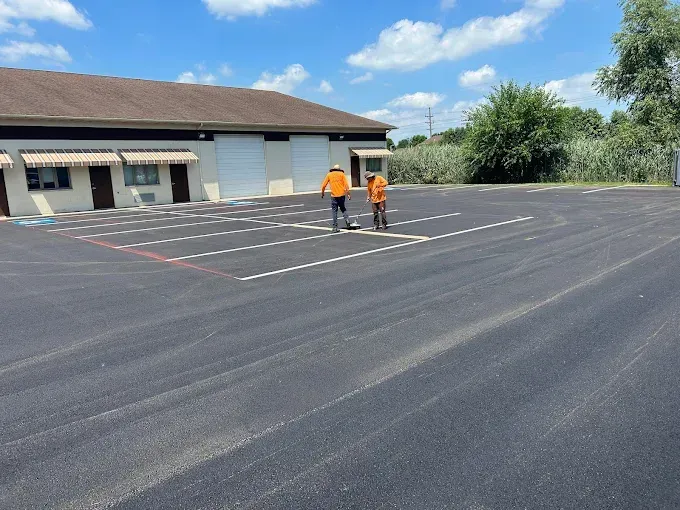 Two men are standing in a parking lot in front of a building
