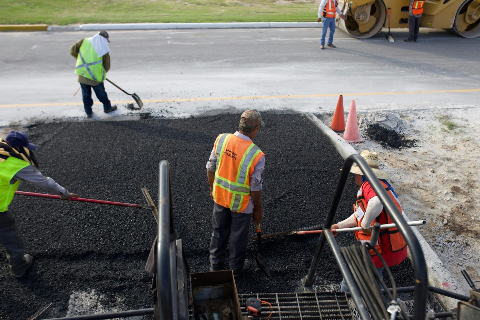 A group of construction workers are working on a road.