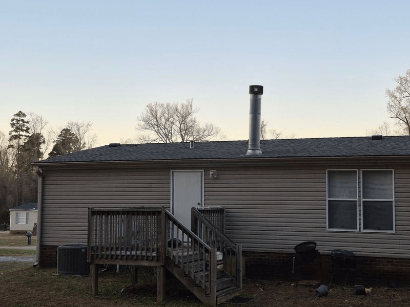 Back of a beige mobile home with a deck