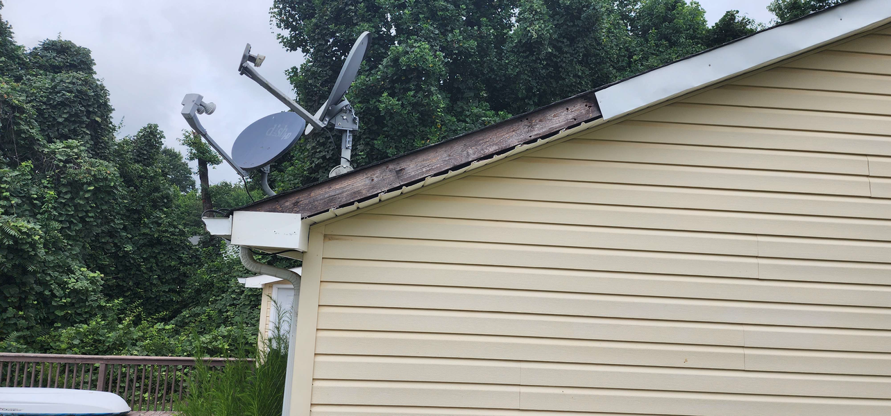 Satellite dishes on a roof of a beige house