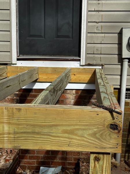 New wooden deck frame under a black door