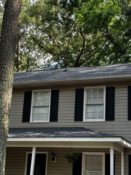House exterior with gray siding, black shutters, and a porch