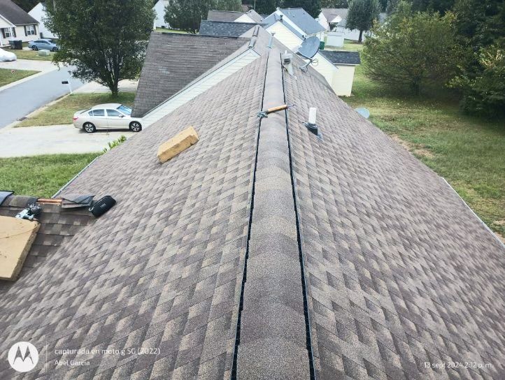 View of a shingled roof with a central valley