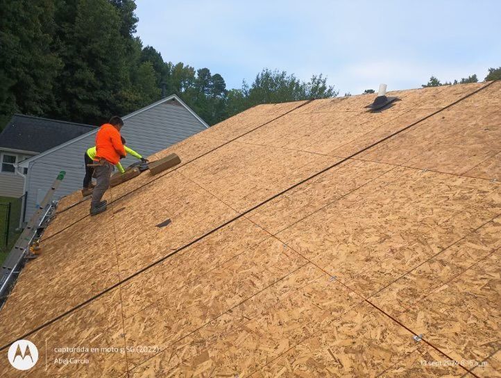 Roofers installing roofing material on a residential home's roof