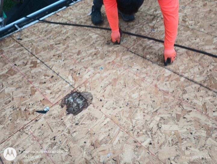 Person on a roof installing shingles