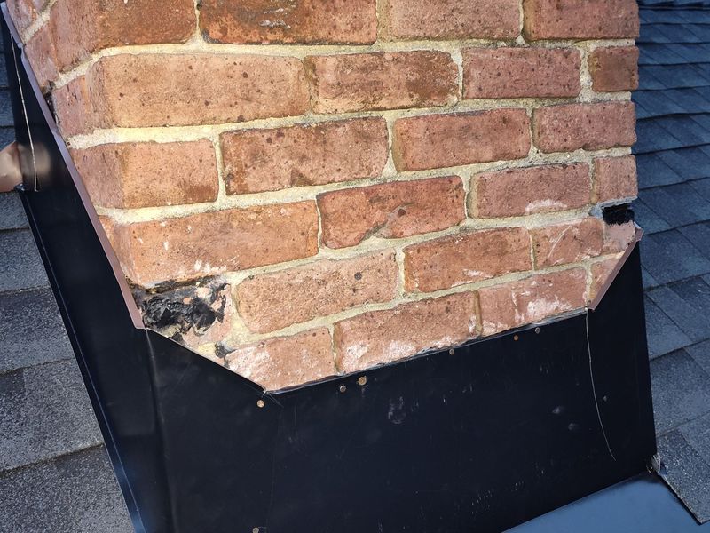 Brick chimney with black flashing around its base
