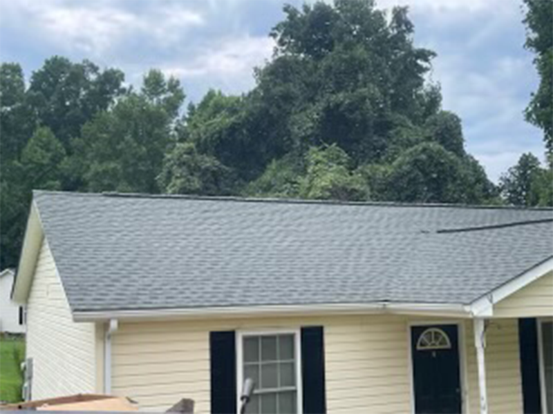 Yellow house with gray roof and black shutters