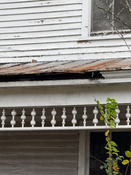 Weathered white house with peeling paint