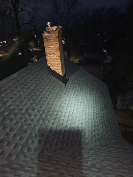 A brick chimney rises from a dark roof