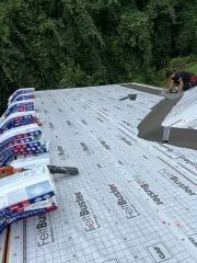 Roofer installing roof underlayment