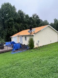 Roofers working on a house with a partially replaced roof
