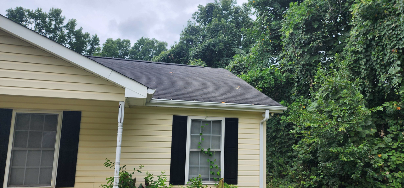 Yellow house with dark roof and black shutters