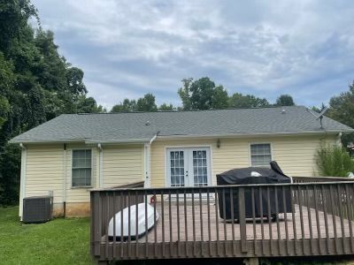 Back of a yellow house with a gray roof