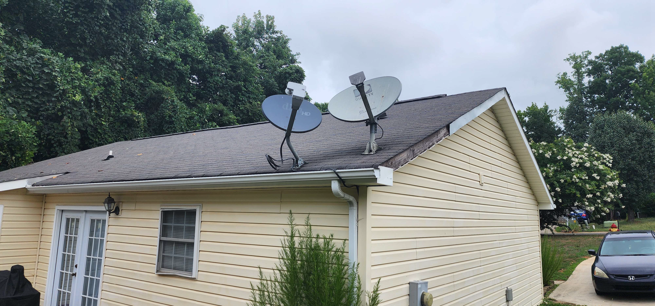 A house with two satellite dishes on the roof