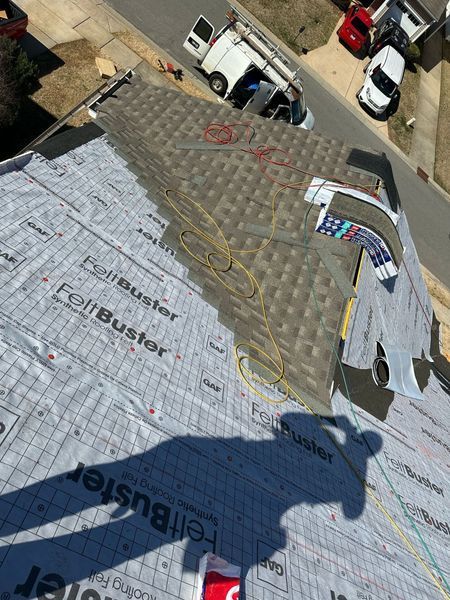 Roofer installing shingles on a house roof