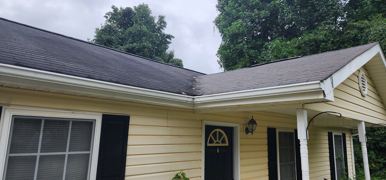 Yellow house with dark roof and black shutters