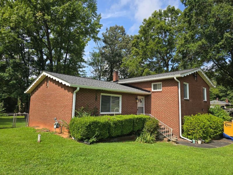Red brick ranch house with green lawn