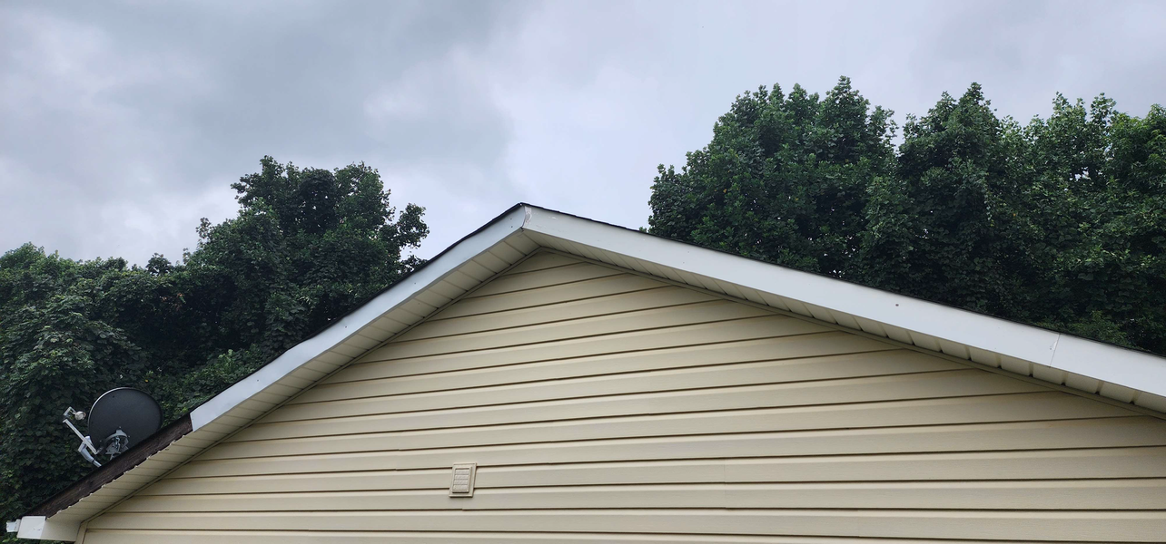 A tan house's roof with a satellite dish