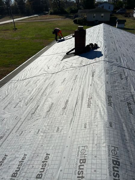 Roofer installing roofing felt on a residential roof
