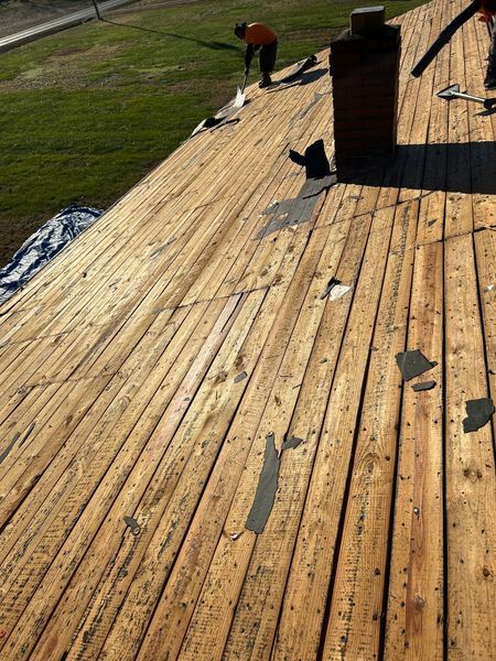 Workers on a weathered wooden roof