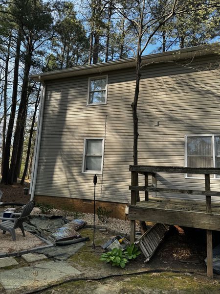 Side view of a two-story house with a tree growing beside it
