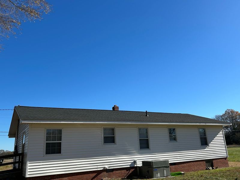 White house with a black roof against a clear blue sky