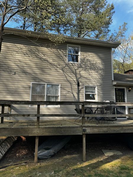 Back of a two-story house with a wooden dec