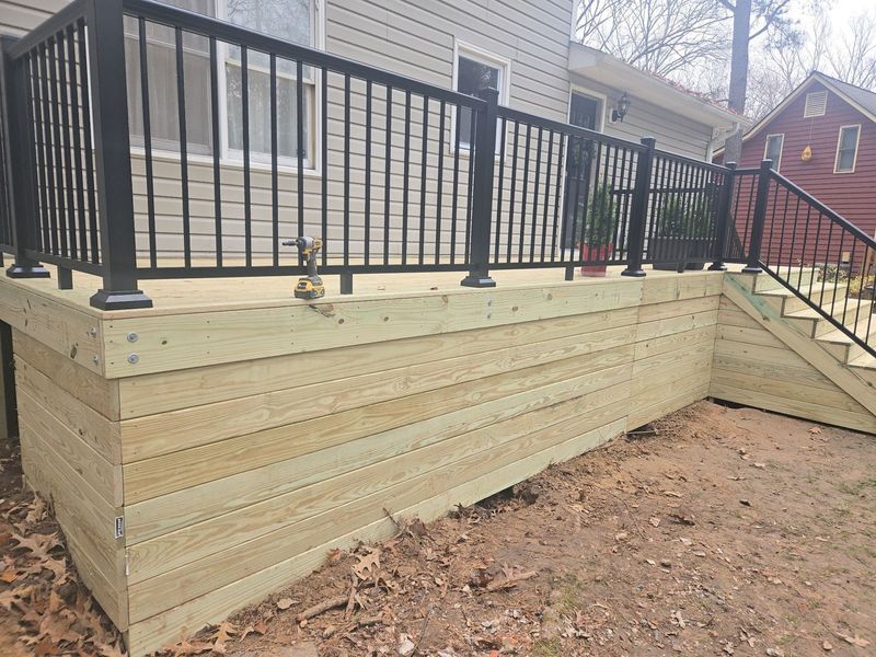 Newly built wooden deck with black railing and stairs