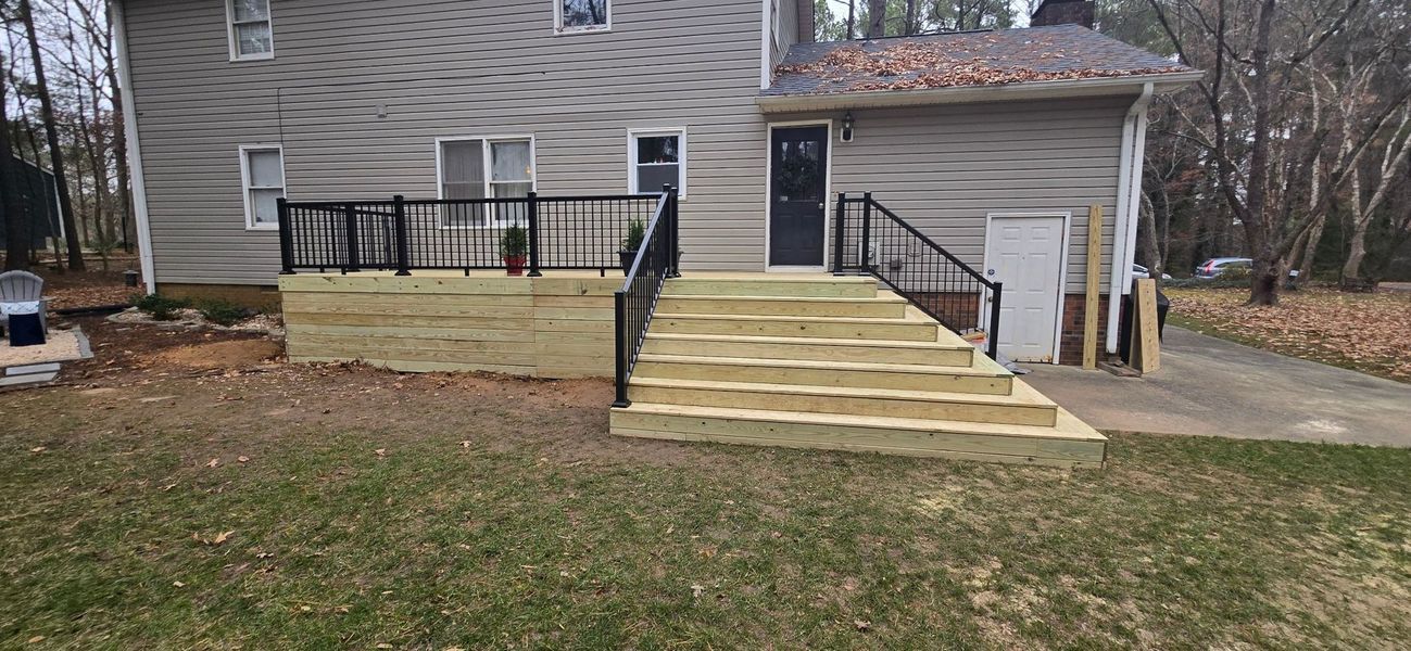 Back of a house with new wooden deck and stairs