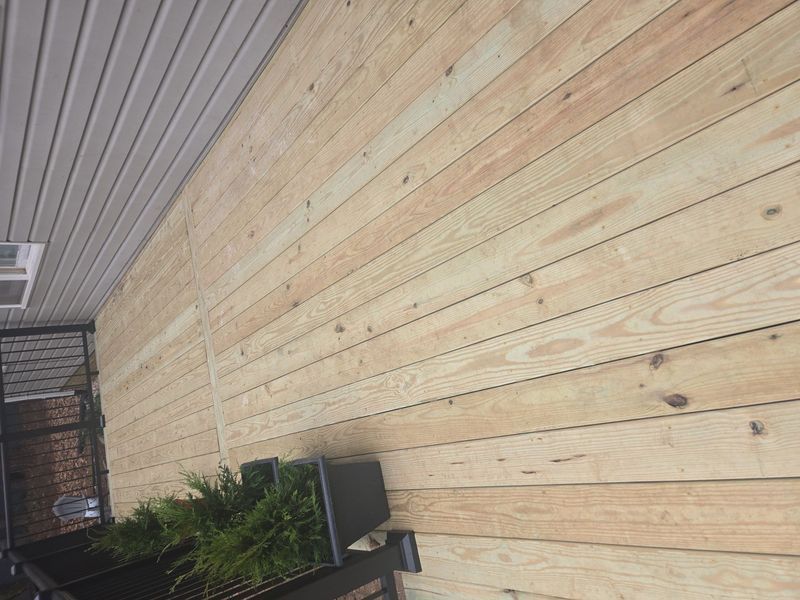 Wooden wall with light-colored planks, topped with white panels
