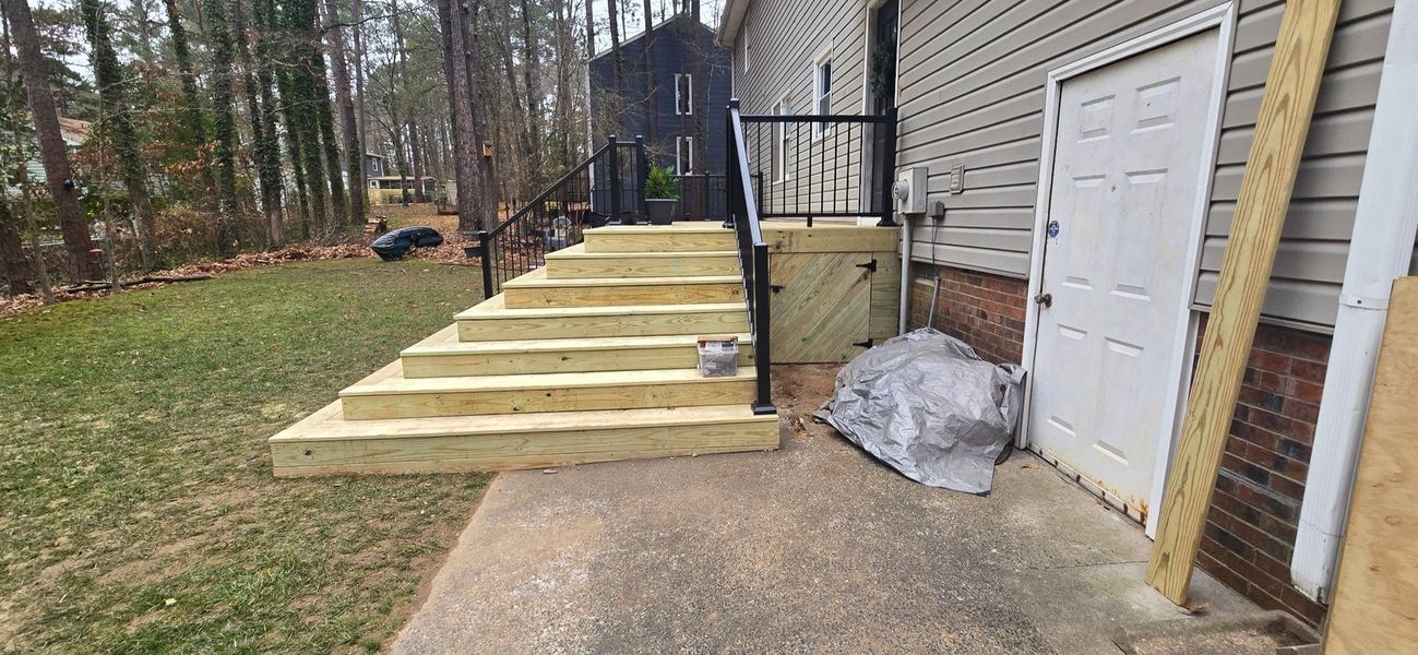 New wooden stairs leading up to a house with a white door